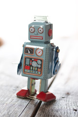 Spielzeug Blechroboter, Metapher für Social Bot / Chatbot auf Holzuntergrund