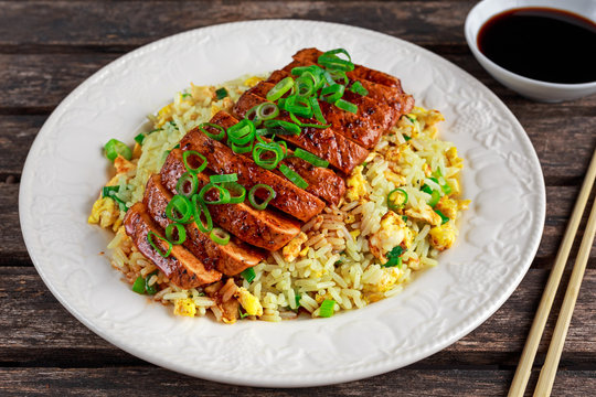 Chinese Style Egg Fried Rice With Sliced Pork Fillet On Wooden Table.