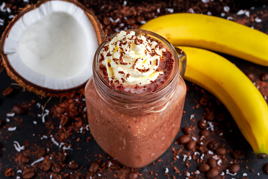 Coconut Coffee Chocolate Banana Smoothie With Whipped Cream On Decorated Table.