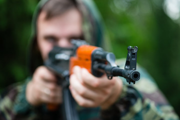 Obraz premium Armed soldier in camouflage with a Kalashnikov assault rifle, so