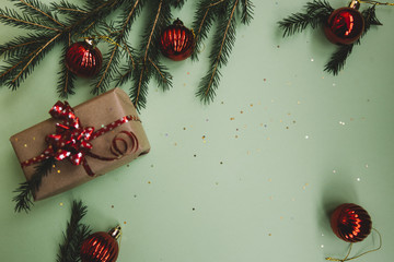 Holiday (Christmas and New year) gift with christmas decoration,tinsel, pine branches on the green...