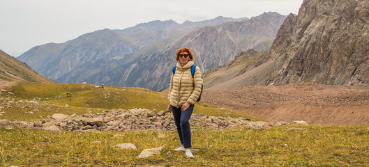 Obraz premium Aged sport woman in sunglasses are standing in the mountains, Ti