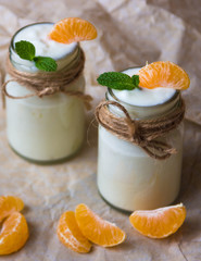 Organic yougurt with fresh tangerine and mint in glass jars
