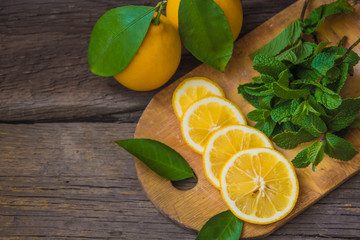 Fresh mint and lemon slices on wooden board