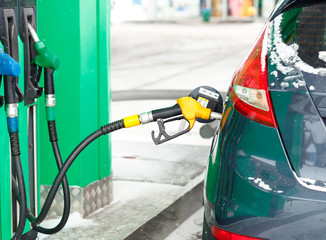Car refueling on a petrol station in winter close up
