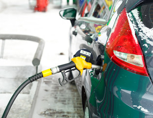 Car refueling on a petrol station in winter close up