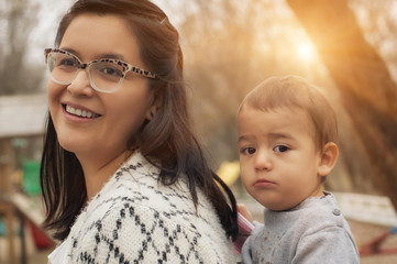 Young mother with her baby boy in a baby carrier scarf