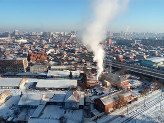 Winter town. Frosty sunny day in the city. Snow on the streets and smoke from the boiler rises. Frost and sun, a wonderful day