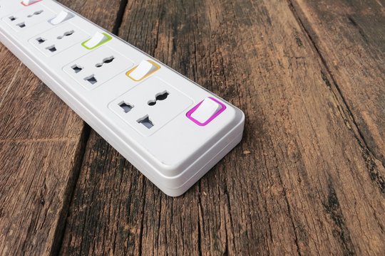 White Plug Socket Electric Power Bar Or Extension Block On Wood Background