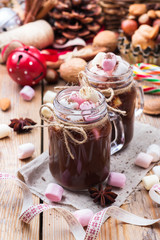 Hot chocolate with marshmallows and spices on christmas table