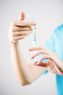 woman nurse or doctor is tapping a syringe preparing an injection