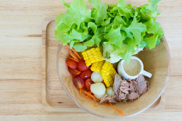 Tuna salad with vegetable on wooden bowl and wooden table