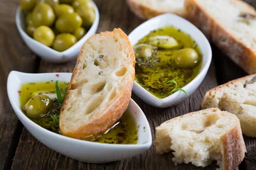 Foto op Plexiglas Het brood gedoopt in olijfolie met kruiden en specerijen © Ruslan Mitin