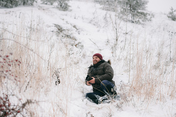 Fototapeta na wymiar cheerful traveler photographer slipped and fell on snow