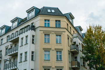 Fototapeta premium city corner house with white and yellow facade