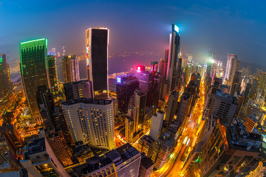Aerial view of Hong Kong skyscrapers at night from a roof, located in Wan Chai district, Hong Kong island. Fisheye view.