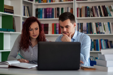 Handsome brunette guy and beautiful redhead student girl serious