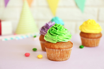 Fresh tasty cupcakes and birthday decor on blurred background