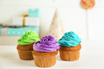 Fresh tasty cupcakes and birthday decor on blurred background