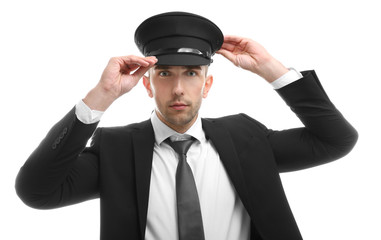 Young chauffeur adjusting his hat on white background