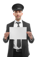 Young chauffeur holding white board on white background