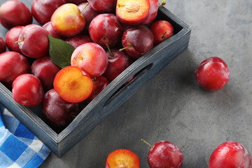 Fresh plums on a grey wooden table