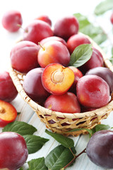 Fresh plums on a white wooden table