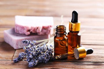 Lavender oil with soap and flowers on brown wooden table