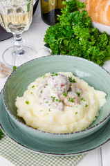 Meatballs in a creamy sauce with mushrooms and mashed potatoes in a plate
