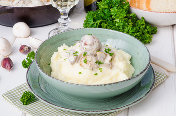 Meatballs in a creamy sauce with mushrooms and mashed potatoes in a plate