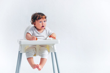 Happy baby boy sitting on studio background