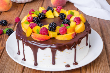 Vanilla mousse cake with peaches and chocolate glaze