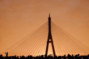 Obraz premium Elevated expressway / Silhouette of elevated expressway and crowd of people cross the river at twilight. Movement.