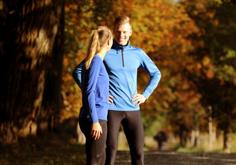 Junges Läuferpaar im Herbst freut sich über das erfolgreiche Training