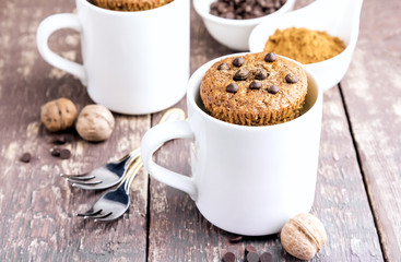 Chocolate muffins with chocolate drops served in white mugs