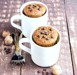 Chocolate muffins with chocolate drops served in white mugs