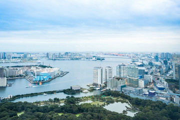 Business and culture concept - panoramic modern city skyline bird eye aerial view of Odaiba bay and rainbow bridge under dramatic morning blue cloudy sky in Tokyo, Japan..