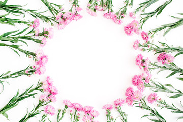 Wreath frame made of pink wildflowers, green leaves, branches on white background. Flat lay, top view. Valentine's background