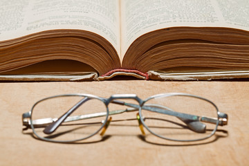 Open old book and glasses.