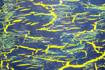 Cracked blue paint on the yellow surface