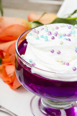 Colorful jelly with whipped cream and candy topping