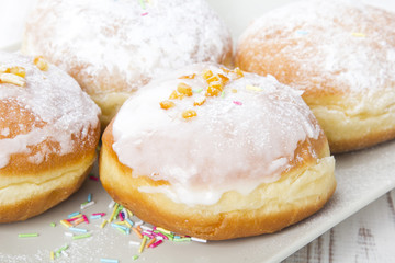 donuts with frosting and powdered sugar on a platter