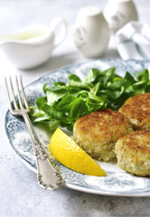 Fish cutlets with cream sauce on a vintage plate.Top view.