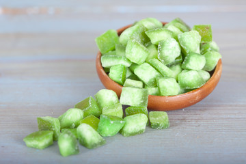 Dried green pomelo squares in wooden bowl 