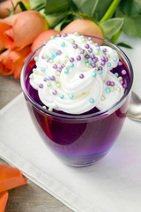Colorful jelly with whipped cream and candy topping