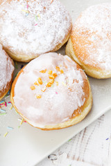 donuts with frosting and powdered sugar on a platter