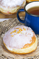 Classic glazed doughnuts and mug of tea 