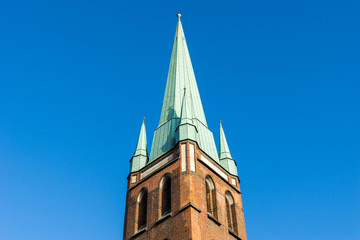 Fototapeta na wymiar Kirchturm mit Kupferdach bei blauem Himmel