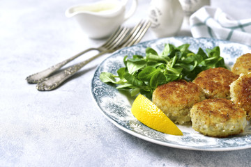 Fish cutlets with cream sauce on a vintage plate.Top view.