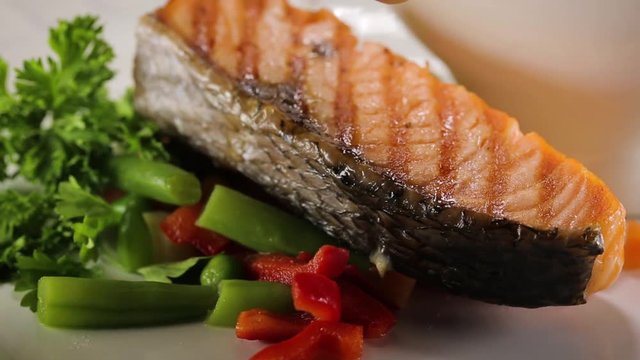 Juicing the lemon juice on the prepared salmon